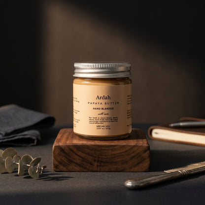 Jar of Ardah Papaya Butter on a wooden block with a dark background