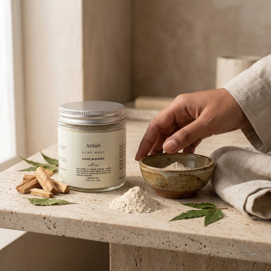 Ardah acne mask container on a stone surface with a hand reaching for a bowl of powder.